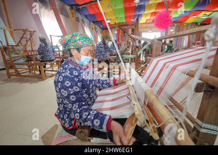 YONGJI, CHINA - 4. MÄRZ 2022 - Textilkünstler arbeiten in einer Weberei-Werkstatt in der Stadt Yongji, der nordchinesischen Provinz Shanxi, 4. März 2022. Stockfoto