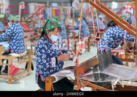 YONGJI, CHINA - 4. MÄRZ 2022 - Textilkünstler arbeiten in einer Weberei-Werkstatt in der Stadt Yongji, der nordchinesischen Provinz Shanxi, 4. März 2022. Stockfoto