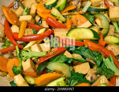 Tofu-Rührbraten mit Paprika, Zucchini, Karotten und Pak Choy. Tofu und Gemüse in einer Pfanne. Eine Mischung aus Gemüse in einem pflanzlichen Abendessen. Stockfoto