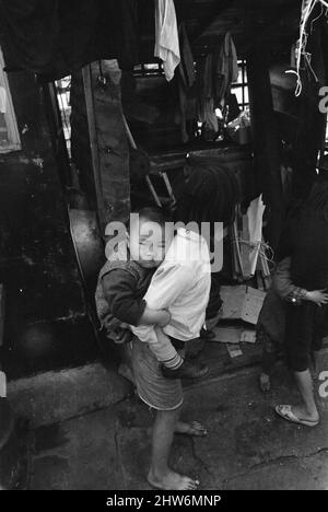 Das Leben im Jahr 1960s das koloniale Hongkong mit einer rapide wachsenden Bevölkerung von mehr als 4 Millionen Menschen, viele sind gezwungen, in Besetzerhütten und Kleinstädten zu leben, aufgenommen im Januar 1968. Unser Bild zeigt ... junges Mädchen kümmert sich um ihren noch jüngeren Bruder. Stockfoto