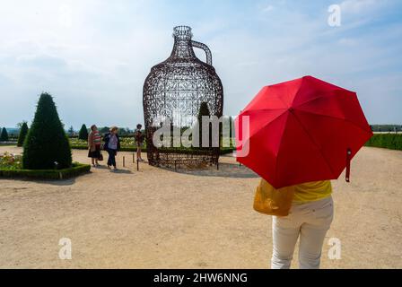 Versailles, Frankreich, Tourist von hinten mit Red Sun Regenschirm, Blick auf moderne Kunst im Französischen Garten, in der Nähe des historischen Schlosses, Schloss Stockfoto