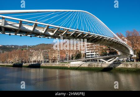 Die Zubizuri (baskisch für „weiße Brücke“) ist eine Fußbrücke mit gebundenem Bogen, die sich über den Fluss Nervion in Bilbao, Spanien, erstreckt Stockfoto