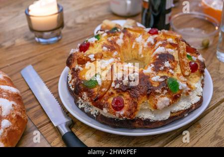 Eine traditionelle Roscón De Reyes (Kuchen der spanischen Könige) eine kronenförmige Torte, gefüllt mit frischer Creme und enthält eine überraschende Keramikfigur, die darin versteckt ist Stockfoto