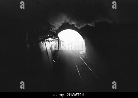 Nummer 34021 'Dartmoor' eine Bulleid Pacific Lokomotive der West Country Class, die hier vor dem retirement30.. April 1967 zum letzten Mal aus einem Tunnel auftauchend von Salisbury, Wiltshire, nach London, Waterloo, auftaucht. Stockfoto