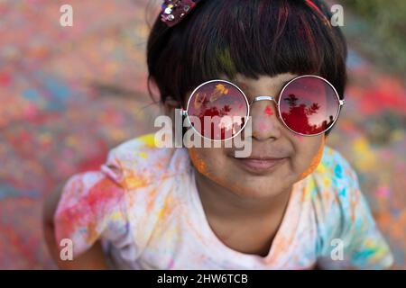 Indian Festive Theme - Happy Asian Kid Baby Girl Having Fun With Non Toxic Herbal Holi Color Powder Called Gulal Or Abir Rang Abeer Stockfoto