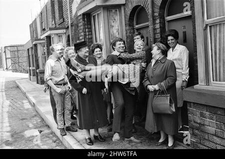 Eine neue Straßeneinstellung für die „Coronation Street“. Granada TV hat ein Outdoor-Set für einige der Szenen gebaut. Im Bild sind die Darsteller Dennis Tanner (Philip Lowrie) mit seiner Braut Jenny Sutton (Mitzi Rogers) nach ihrer Hochzeit mit Annie Walker (Doris Speed), Ena Sharples (Violet Carson), Emily Nugent (Eileen Derbyshire), Ken Barlow (William Roache) und Elsie Tanner (Pat Phoenix). 18. Mai 1968. Stockfoto