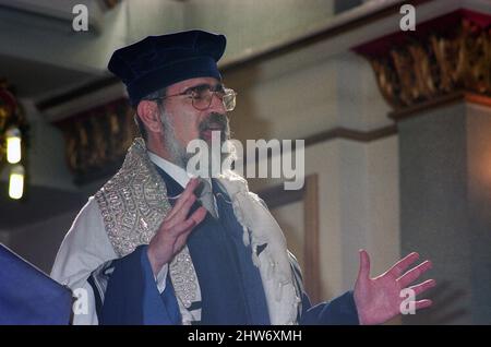 Der Oberrabbiner Lord Jonathan Sacks hält eine Predigt aus der Bima in der Schule (Synagoge). Der Oberrabbiner Jonathan Sacks war Ehrengast für die Aufnahme der letzten Briefe in eine neue Sefer-Torah in der Synagoge der hebräischen Kongregation Singers Hill am Sonntag, dem 15. März 1998. Mitglieder der Gemeinde sowie der Oberrabbiner fügten jeweils einen einzigen Brief hinzu. Stockfoto