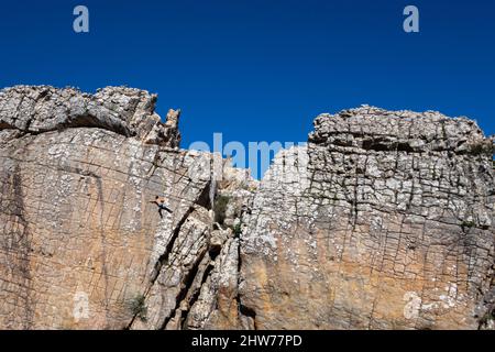Einzelkletterer für Männer, die eine vertikale Seillänge in der Zona de Escalada Tajo del Buho in Betis, in der Nähe von Tarifa in Spanien, klettern Stockfoto