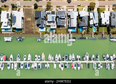 Luftaufnahme von oben auf moderne Häuser am Wasser mit Liegeplatz in Melbourne Stockfoto