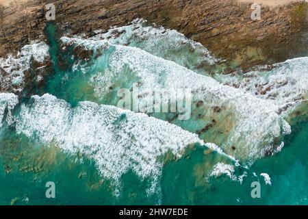Luftaufnahme von oben nach unten von Meereswellen, die an felsiger Küste entlang der Great Ocean Road in Australien krachen Stockfoto