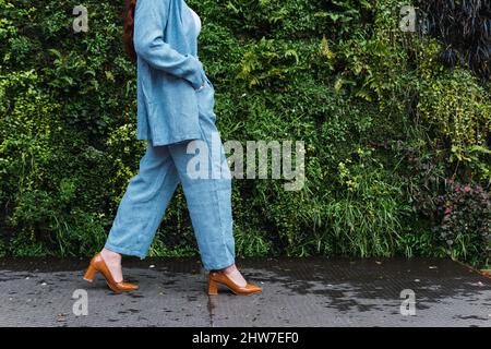 Nicht erkennbare Geschäftsfrau in blauem Anzug, die auf der Straße läuft Stockfoto