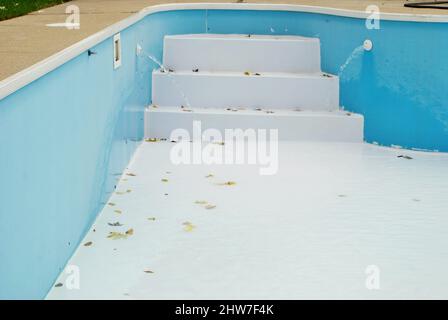 Hinterhof-Swimmingpool mit leertem Treppenaufgang, für den man abschalten musste Winter Stockfoto