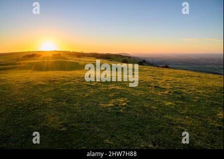 Herrliches Licht und lange Schatten bei Sonnenuntergang auf South Downs westlich von Ditchling Beacon in East Sussex, England. Stockfoto