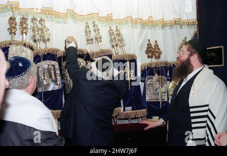 Die neue Sefer Torah wird in der Aaron Hakodesh (Arche) platziert, die die Zeremonie beendet. Der Oberrabbiner Jonathan Sacks war Ehrengast für die Aufnahme der letzten Briefe in eine neue Sefer-Torah in der Synagoge der hebräischen Kongregation Singers Hill am Sonntag, dem 15. März 1998. Mitglieder der Gemeinde sowie der Oberrabbiner fügten jeweils einen einzigen Brief hinzu. Stockfoto