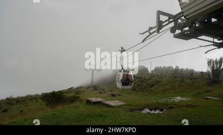 Quito, Pichincha, Ecuador - Februar 26 2022: Kabine mit Passagieren, die an einem sehr bewölkten Tag an der Seilbahn in Cruz Loma ankommen Stockfoto