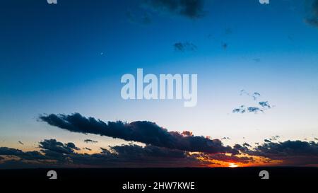 Hypnotisierende Szene eines großen bunten Himmels mit grauen Wolken am Sonnenuntergangshimmel Stockfoto