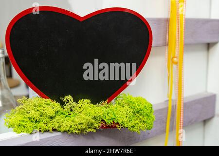 Herzförmige Tafel mit grünem Moos Stockfoto