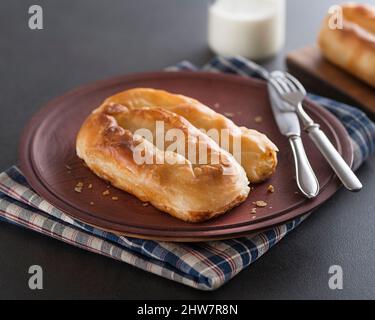 Gefüllter Kuchen mit Käse, serviert mit Joghurt. Traditionelle Burek- balkan-Phyllo-Pastete. Stockfoto