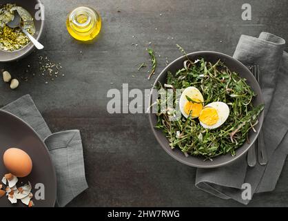 Frischer, frühlingsgrüner Dandelionssalat mit Eiern auf einem Teller Stockfoto