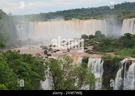 Nahsicht der Aussichtsplattform und Brücken für Touristen der Cataratas Wasser fällt unter blauen Himmel, Regenbogen und einem Wassernebel am Foz do Iguassu pa Stockfoto