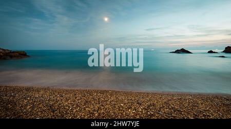 Meer in der Nacht. Kinofilter. Mittelmeerküste. Kieselsteine am Strand. Ligurien in Italien. Langzeitbelichtung. Stockfoto