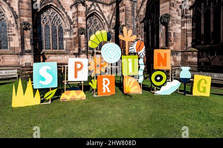 Frühling in Chester, ein großes Frühlingsschild auf dem Gelände der Kathedrale, Stockfoto