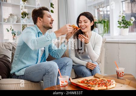 Paar teilen Pizza und Essen Stockfoto