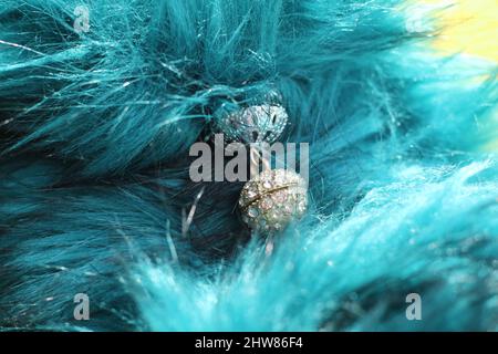 Modekonzept - Makro-Detail von Cyan-blauen Kunstpelz mit silberner Schließe Stockfoto