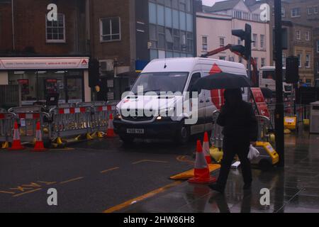 Man überquert Straße an der Ampel in einer Stadtstraße, Chelmsford, Essex, Großbritannien. Stockfoto