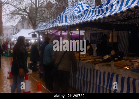 An einem Fischhändler-Stand in Chelmsford, Essex, Großbritannien, warten im Regen Einkäufer auf frischen Fisch. Stockfoto