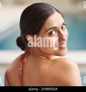 Der beste Weg, um einen heißen Nachmittag zu verbringen. Aufnahme einer jungen Frau, die sich am Pool entspannt. Stockfoto