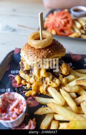 Mac Attack Burger garniert mit mac und Käse mit Pommes bei Liquor & Loaded, King's Lynn, Norfolk, Großbritannien Stockfoto