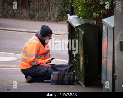 OpenREACH BT-Ingenieur arbeitet an der Abzweigdose für Straßenkommunikationsschränke in der Londoner Straße Stockfoto