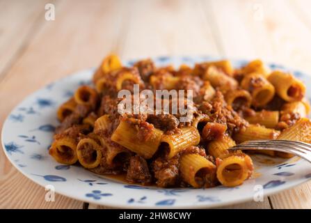 Rigatoni oder Penne mit Bolognese-Sauce auf einem Teller. Nahaufnahme Stockfoto