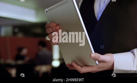 Nahaufnahme der Kellnerhand, die das Menü auf dem Tablet notiert. Lager. Kellner mit dem Tablett. Stockfoto