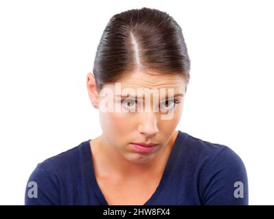 Wirst du mir vergeben? Studioaufnahme einer jungen Frau, die beschämt auf Weiß schaut. Stockfoto