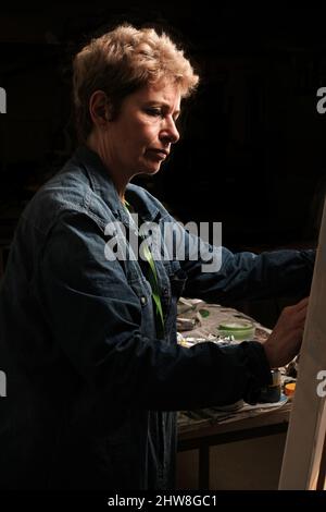 Künstlerin (Fiona Kelly) arbeitet auf Leinwand Stockfoto