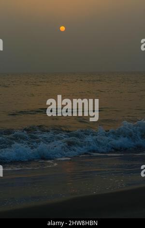 Unglaublich schöner Sonnenuntergang am Strand. Sonne, Himmel, Meer, Wellen und Sand. Ein Urlaub am Meer. Stockfoto