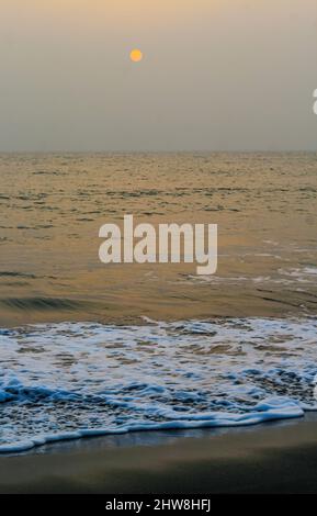 Unglaublich schöner Sonnenuntergang am Strand. Sonne, Himmel, Meer, Wellen und Sand. Ein Urlaub am Meer. Stockfoto