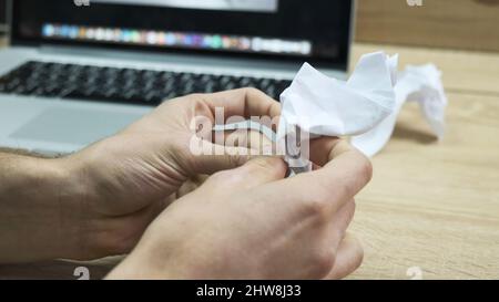 Mann machte eine hässliche Origami-Figur und vergleicht sie mit einer schönen auf dem Bildschirm. Konzept der kreativen Aktivitäten, Nahaufnahme der männlichen Hände Herstellung Origami auf Stockfoto