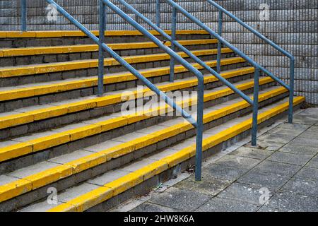 Betontreppe im Freien mit gelben Sicherheitsmarkierungen und Geländern Stockfoto