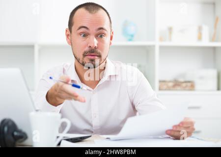 Junger Geschäftsmann, der im Büro spricht Stockfoto
