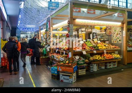 Menschen, die Obst und Gemüse in der Markthalle Mercato Annonario im historischen Zentrum von Sanremo, Imperia, Ligurien, Italien kaufen Stockfoto