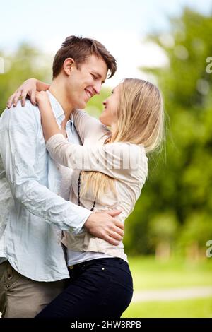 Gemeinsam Spaß haben. Junges Paar, das im Park zusammensteht. Stockfoto