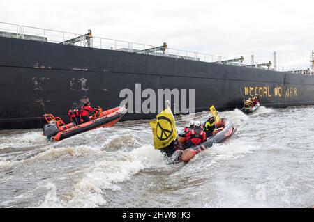 Wedel, Deutschland. 04. März 2022. Aktivisten von Greenpeace fahren auf der Elbe zwischen Wedel (Schleswig-Holstein) und Hamburg mit Gummijollen, um den Kohlefrachter "Grand T", der auf dem Weg zum Hamburger Hafen mit russischer Kohle beladen ist, mit dem Slogan "No Coal no war" zu besetzen. Quelle: Daniel Bockwoldt/dpa/Alamy Live News Stockfoto