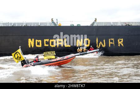 Wedel, Deutschland. 04. März 2022. Aktivisten von Greenpeace fahren auf der Elbe zwischen Wedel (Schleswig-Holstein) und Hamburg mit Gummijollen, um den Kohlefrachter "Grand T", der auf dem Weg zum Hamburger Hafen mit russischer Kohle beladen ist, mit dem Slogan "No Coal no war" zu besetzen. Quelle: Daniel Bockwoldt/dpa/Alamy Live News Stockfoto