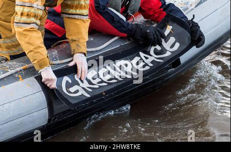 Wedel, Deutschland. 04. März 2022. Greenpeace-Aktivisten bereiten auf der Elbe zwischen Wedel (Schleswig-Holstein) und Hamburg ein Schlauchboot vor, um einen mit russischer Kohle beladenen Kohlefrachter mit dem Slogan "No Coal no war" in den Hamburger Hafen zu bringen. Quelle: Daniel Bockwoldt/dpa/Alamy Live News Stockfoto