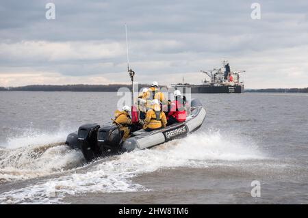 Wedel, Deutschland. 04. März 2022. Aktivisten von Greenpeace fahren auf der Elbe zwischen Wedel (Schleswig-Holstein) und Hamburg mit Gummijollen, um den Kohlefrachter "Grand T", der auf dem Weg zum Hamburger Hafen mit russischer Kohle beladen ist, mit dem Slogan "No Coal no war" zu besetzen. Quelle: Daniel Bockwoldt/dpa/Alamy Live News Stockfoto