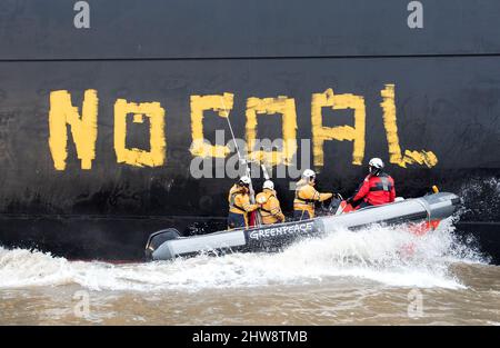 Wedel, Deutschland. 04. März 2022. Aktivisten von Greenpeace fahren auf der Elbe zwischen Wedel (Schleswig-Holstein) und Hamburg mit Gummijollen, um den Kohlefrachter "Grand T", der auf dem Weg zum Hamburger Hafen mit russischer Kohle beladen ist, mit dem Slogan "No Coal no war" zu besetzen. Quelle: Daniel Bockwoldt/dpa/Alamy Live News Stockfoto