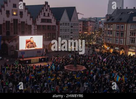 Frankfurt am Main, Deutschland. 04. März 2022. 04. März 2022, Hessen, Frankfurt/Main: Mehrere tausend Menschen nehmen an einer Solidaritätskundgebung für die Ukraine auf dem Römerberg in Frankfurt Teil. Der ukrainische Präsident Wolodymyr Selenskyj ist live auf einer Leinwand zu sehen. Foto: Boris Roessler/dpa Quelle: dpa picture Alliance/Alamy Live News Stockfoto